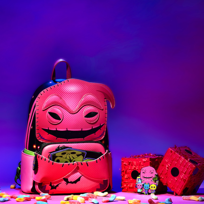 Image of our pink Oogie Boogie Neon Cosplay Mini Backpack, featuring Oogie Boogie in a Funko Pop! art style next to fuzzy dice and a matching Oogie Boogie 3" pin with Lock, Shock, and Barrel